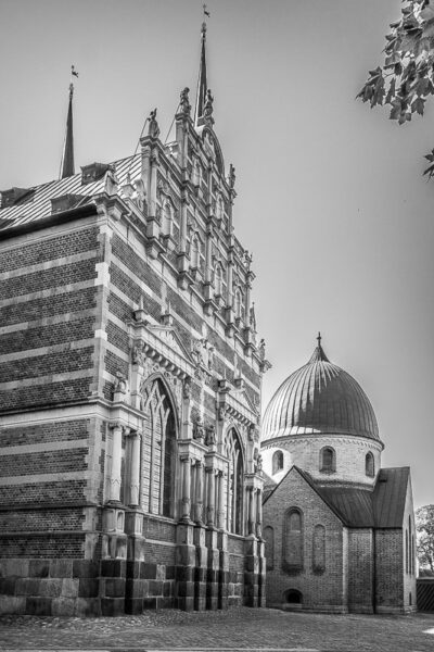 Datum: 2014:09:05 13:48:28 Der Dom zu Roskilde ist der erste gotische Dom Skandinaviens aus Backstein. Der Bau der Backsteinkirche wurde in den 1170er Jahren im romanischen Stil begonnen und um 1280 mit dem gotischen Chor beendet. In den folgenden Jahrhunderten wurden mehrere Kapellen innerhalb und außerhalb der Kirche angebaut. Ursprünglich diversen Heiligen gewidmet, wurden sie später durch Grabkapellen und Mausoleen der Könige im jeweiligen Stil der Zeit ersetzt.