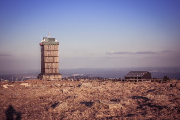 Datum: 2015:04:18 19:22:00 Der Brocken ist mit 1141,2 m ü. NHN der höchste Berg im Norden Deutschlands und des Mittelgebirges Harz. Bereits in der Bronzezeit diente der Brocken vermutlich als Landmarke für das Observatorium auf dem 85 Kilometer entfernten Mittelberg. Zur Sommersonnenwende geht von dort aus die Sonne hinter dem Brocken unter, so dass die auf dem Mittelberg gefundene Himmelsscheibe von Nebra sich anhand der Sichtlinie zum Brocken und der auf der Scheibe angebrachten Horizontbögen exakt ausrichten ließ. Das erste Gasthaus unmittelbar auf der Brockenkuppe wurde 1800 erbaut. Die schmalspurige Brockenbahn wurde am 27. März 1899 eröffnet.