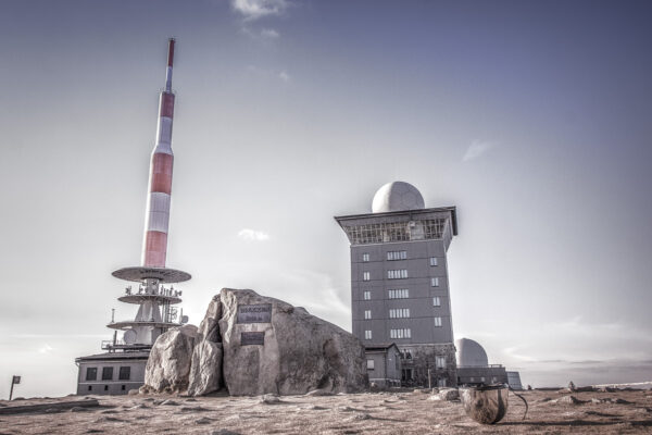 Datum: 2015:04:18 19:23:20 Der Brocken ist mit 1141,2 m ü. NHN der höchste Berg im Norden Deutschlands und des Mittelgebirges Harz. Bereits in der Bronzezeit diente der Brocken vermutlich als Landmarke für das Observatorium auf dem 85 Kilometer entfernten Mittelberg. Zur Sommersonnenwende geht von dort aus die Sonne hinter dem Brocken unter, so dass die auf dem Mittelberg gefundene Himmelsscheibe von Nebra sich anhand der Sichtlinie zum Brocken und der auf der Scheibe angebrachten Horizontbögen exakt ausrichten ließ. Das erste Gasthaus unmittelbar auf der Brockenkuppe wurde 1800 erbaut. Die schmalspurige Brockenbahn wurde am 27. März 1899 eröffnet.